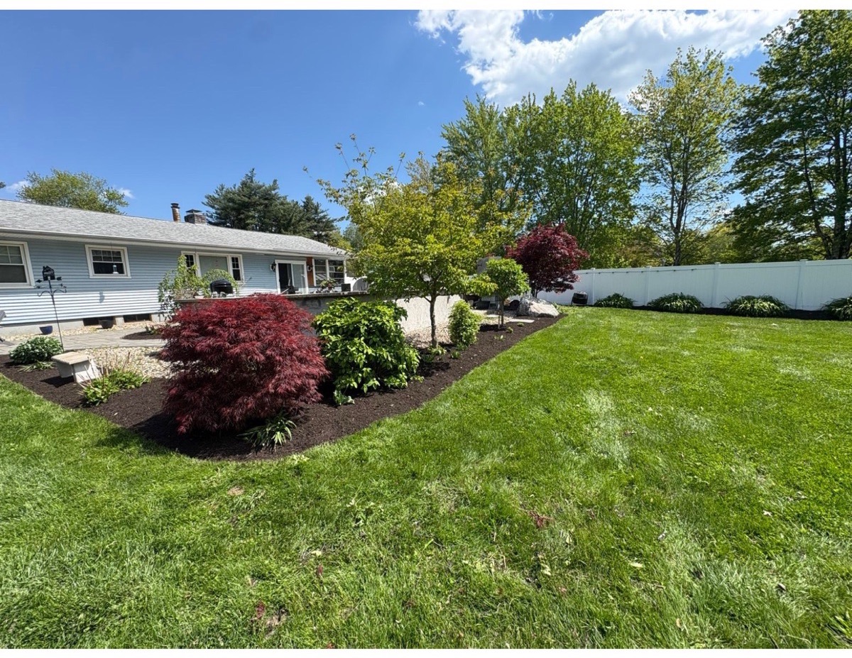 Maintained residential landscape with red maple and mulched beds